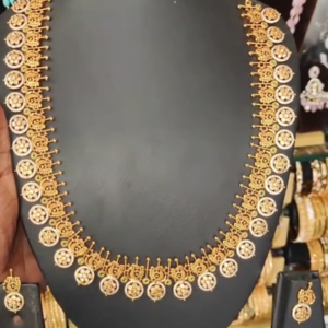 22K gold-plated traditional temple necklace set with ruby, emerald, and zirconia accents, featuring intricate designs and matching earrings