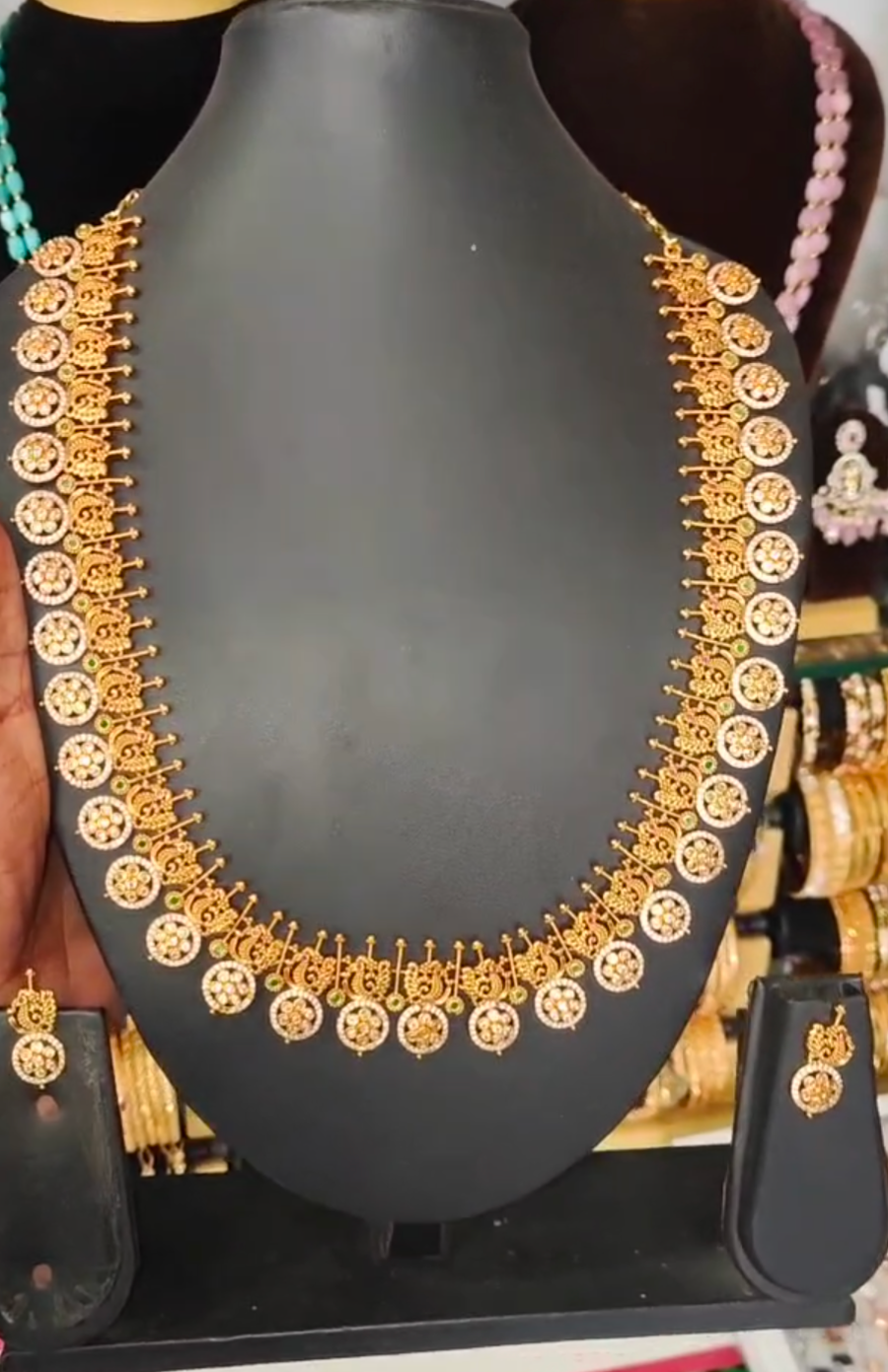 22K gold-plated traditional temple necklace set with ruby, emerald, and zirconia accents, featuring intricate designs and matching earrings